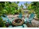 Outdoor fire pit surrounded by Adirondack chairs and lush tropical landscaping creating a relaxing and inviting space at 1151 Lancer Ln, Tarpon Springs, FL 34689