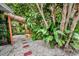 Shaded outdoor area with wooden pergola, lattice accent, bench, pathway and abundant greenery providing a serene escape at 1151 Lancer Ln, Tarpon Springs, FL 34689