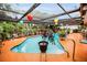 Beautiful screened pool with colorful lanterns and lush landscaping, creating a serene oasis at 1151 Lancer Ln, Tarpon Springs, FL 34689