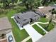 This aerial view features a home with a long driveway, attached garage, and well-maintained lawn with mature trees at 12807 Starling Dr, Odessa, FL 33556