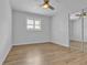 Open bedroom area featuring a ceiling fan, hardwood floors, and a mirrored closet at 12807 Starling Dr, Odessa, FL 33556