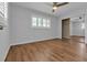 Open bedroom area featuring a ceiling fan, hardwood floors, and a mirrored closet at 12807 Starling Dr, Odessa, FL 33556