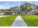 Well-maintained single-story home with manicured lawn and walkway leading to the front door at 12807 Starling Dr, Odessa, FL 33556