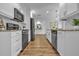 Modern kitchen with stainless steel appliances, white cabinets, and wood floors at 12807 Starling Dr, Odessa, FL 33556