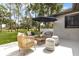 Covered patio area with outdoor seating, umbrella, and a beautiful outdoor view at 12807 Starling Dr, Odessa, FL 33556