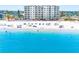 Beautiful beachfront condo building with a pool, tiki umbrellas, and stunning ocean view at 13500 Gulf Blvd # 507, Madeira Beach, FL 33708