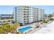 Condominium exterior view featuring a pool and beach access with ample parking available at 13500 Gulf Blvd # 507, Madeira Beach, FL 33708