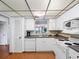 Efficient kitchen featuring white appliances, laminate wood floors and a view to the living area at 13500 Gulf Blvd # 507, Madeira Beach, FL 33708