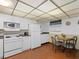 Compact kitchen with white appliances and seating for 4 at 13500 Gulf Blvd # 507, Madeira Beach, FL 33708