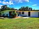 Backyard with a lush lawn, tiled patios, and the exterior of a well-maintained single-story home at 1373 Fairfax Rd, Clearwater, FL 33764