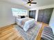Well-lit bedroom featuring ceiling fan, closet, updated flooring, and a comfortable queen-sized bed with updated decor at 1373 Fairfax Rd, Clearwater, FL 33764