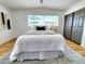 Bright bedroom with updated flooring, gray closet doors, light walls, and a comfortable queen bed with a view at 1373 Fairfax Rd, Clearwater, FL 33764