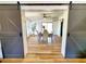 Open dining room featuring light wood flooring, table with chairs and barn door access at 1373 Fairfax Rd, Clearwater, FL 33764