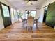 Bright dining room featuring light wood floors, dining table, and sliding barn door access to another room at 1373 Fairfax Rd, Clearwater, FL 33764