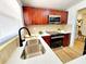 Bright kitchen with stainless steel sink, quartz countertops, stainless appliances, and wooden cabinets at 1373 Fairfax Rd, Clearwater, FL 33764