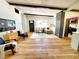 Spacious living room with hardwood floors, exposed beams, and a stylish brick accent wall at 1373 Fairfax Rd, Clearwater, FL 33764