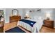 Bedroom showcasing a comfortable bed with a blue throw blanket, wood floors, and natural light at 1400 Tarpon Woods Blvd # A4, Palm Harbor, FL 34685