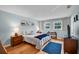 Bright bedroom featuring wood floors, blue accent rug, and abundant natural light from two windows at 1400 Tarpon Woods Blvd # A4, Palm Harbor, FL 34685