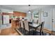 A dining room with modern lighting, wood floors, an area rug and a partial view of the kitchen at 1400 Tarpon Woods Blvd # A4, Palm Harbor, FL 34685
