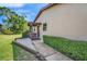 A charming home entrance featuring a covered porch, manicured hedges, and a paved walkway at 1400 Tarpon Woods Blvd # A4, Palm Harbor, FL 34685