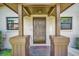 A welcoming front porch with dark wood columns, a neutral door, and symmetrical windows at 1400 Tarpon Woods Blvd # A4, Palm Harbor, FL 34685