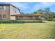 Exterior view of the home featuring a sunroom and lush green lawn at 1400 Tarpon Woods Blvd # A4, Palm Harbor, FL 34685