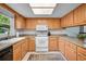 A bright kitchen with wood cabinets, white appliances, and a neutral countertop at 1400 Tarpon Woods Blvd # A4, Palm Harbor, FL 34685