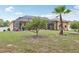 Large backyard with a screened-in lanai, a palm tree, and a charming garden area at 14494 Copeland Way, Brooksville, FL 34604