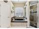 Bathroom with black tub, tile shower, and a window view at 14494 Copeland Way, Brooksville, FL 34604