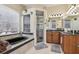 Bathroom with dual sinks, soaking tub, and glass-enclosed shower at 14494 Copeland Way, Brooksville, FL 34604