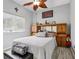 A bedroom features light grey walls, a bed with grey pillows, and a blanket on a leather seat at 14494 Copeland Way, Brooksville, FL 34604