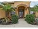 Charming front entrance with brick columns, double glass doors, and lush tropical landscaping at 14494 Copeland Way, Brooksville, FL 34604