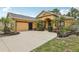 Well-manicured front yard complements this tan home with a large driveway at 14494 Copeland Way, Brooksville, FL 34604