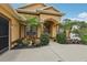 Charming home featuring lush landscaping, palm trees, and a red front door at 14494 Copeland Way, Brooksville, FL 34604