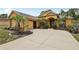 Manicured front yard of tan house features palm trees, cacti, and ample parking at 14494 Copeland Way, Brooksville, FL 34604