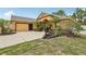 Well-manicured front yard complements this tan home with a large driveway at 14494 Copeland Way, Brooksville, FL 34604
