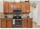 Kitchen showcasing stainless steel appliances, granite counters, and wood cabinetry at 14494 Copeland Way, Brooksville, FL 34604