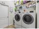 The laundry room has a washer, dryer, and storage shelf at 14494 Copeland Way, Brooksville, FL 34604