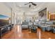 Open-concept living room with wood floors, tray ceiling, and modern gray sectional sofa at 14494 Copeland Way, Brooksville, FL 34604
