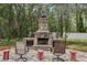 The backyard brick patio features a stone fireplace and comfortable seating at 14494 Copeland Way, Brooksville, FL 34604