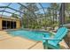 Screened-in pool area with comfortable seating and lush landscaping, perfect for relaxing at 14494 Copeland Way, Brooksville, FL 34604