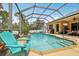 Sparkling screened-in pool area with an outdoor kitchen and seating; ideal for entertaining at 14494 Copeland Way, Brooksville, FL 34604
