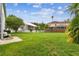 Large grassy backyard with a partial view of the house and a white picket fence at 16003 Ridley Pl, Tampa, FL 33647