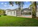 Inviting backyard features a screened-in patio, a sparkling pool, and a lush green lawn at 16003 Ridley Pl, Tampa, FL 33647