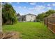 Spacious backyard featuring lush green grass, fenced yard, and a partial view of the screened in porch at 16003 Ridley Pl, Tampa, FL 33647