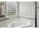 Bright bathroom featuring a modern tub with glass block window and tiled surround at 16003 Ridley Pl, Tampa, FL 33647
