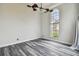 Bedroom with gray wood floors, ceiling fan, and tall window with exterior views at 16003 Ridley Pl, Tampa, FL 33647