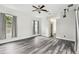 Spacious bedroom with gray wood-look flooring, neutral walls, ceiling fan and two windows with gray curtains at 16003 Ridley Pl, Tampa, FL 33647