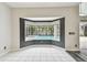 Dining area with a bay window view of the screened-in pool area and white tile flooring at 16003 Ridley Pl, Tampa, FL 33647
