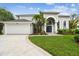 Charming two-story home featuring manicured front yard, archway entrance, and convenient two-car garage at 16003 Ridley Pl, Tampa, FL 33647